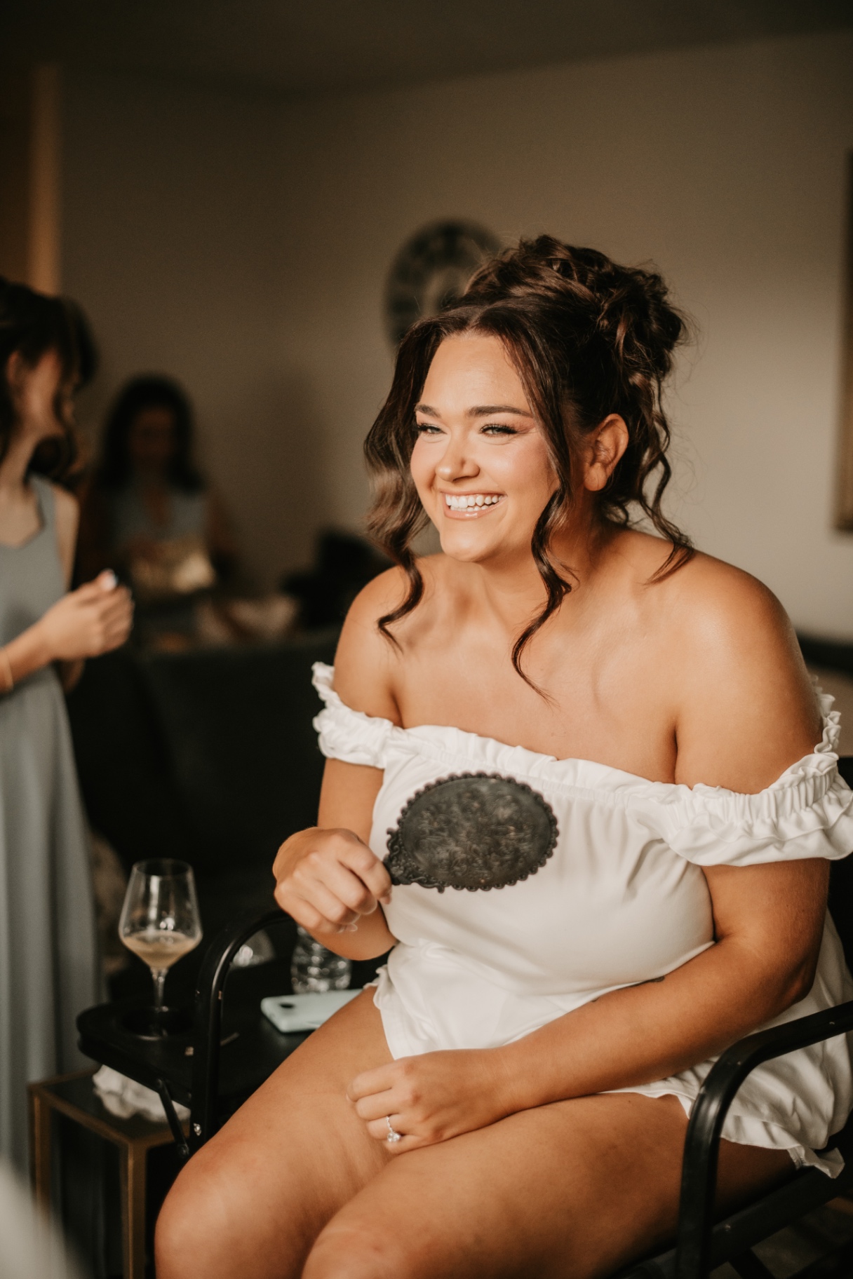 Bride laughing with her bridesmaids while getting ready before the ceremony